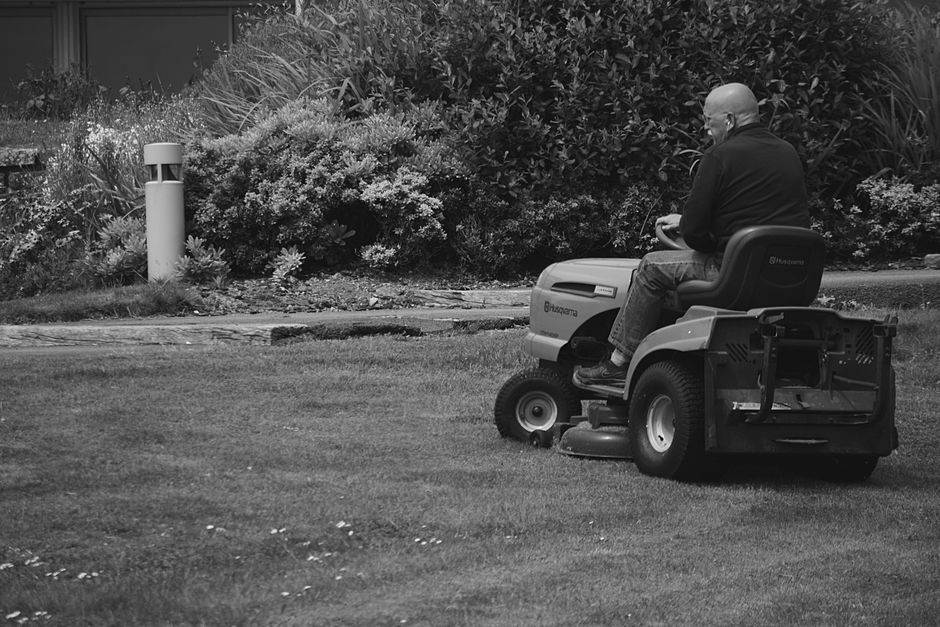 Commercial riding lawn mower cutting grass on a large estate